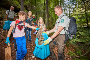 Junior Ranger, naturbegeisterte Kinder sammeln mit Rangrn aus dem Nationalprk Müll.