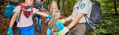 Junior Ranger, naturbegeisterte Kinder sammeln mit Rangrn aus dem Nationalprk Müll.