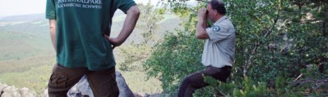 Zwei Ranger, einer mit Fernglass erfassen die Population der Wanderfalken im Natioalpark
