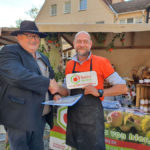 Carsten Ullrich bekommt von Joachim Oswald auf dem diesjährigen Naturmarkt Sächsische Schweiz in Wehlen Glückwünsche zur Mitgliedschaft bei "Gutes von hier."