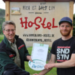 Glückliche Männer am Elbradweg: Pressesprecher Hanspeter Mayr übergibt an Christoph Hubrich die Urkunde und die Emailleplakette. Im Hinterland von Rathen sagt man "Ja" zum Nationalpark!